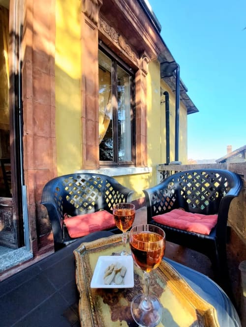 Terrasse ensoleillée au Palazzo Losio avec chaises bleues, coussins rouges, apéritifs et amuse-bouches à Ponzone, Italie