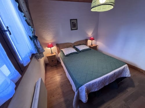 Chambre douillette de Chez Francine à Notre Dame de Bellecombe avec lit double, lampes rouges et tables de nuit en bois