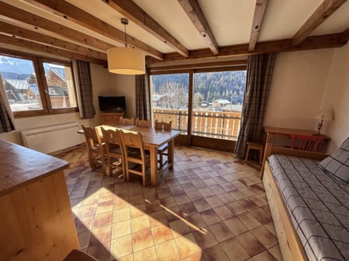 Spacieux appartement alpin Chez Francine avec poutres en bois, vue sur les montagnes, salle à manger et lit à Notre Dame de Bellecombe