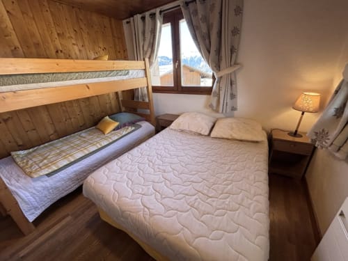 Chambre cosy chez Francine avec lits superposés, lit queen-size, murs en bois et vue sur les montagnes à Notre-Dame-de-Bellecombe