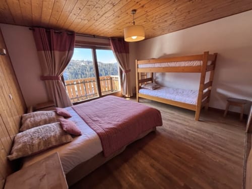 Spacieuse chambre de montagne chez Francine avec lit double, lits superposés, plafond en bois et vue sur les Alpes