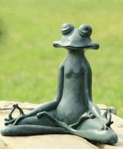 Escultura de piedra de una rana en postura de yoga en el jardín del B&B Casale Artemisia, Capalbio