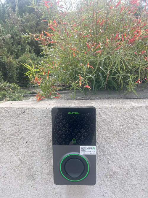 Autel EV charging station at Villa Nais guesthouse in Bormes les Mimosas with flowering plants behind