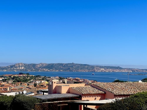 Coastal view of Palau village with terracotta roofs overlooking azure Mediterranean Sea and rocky hills