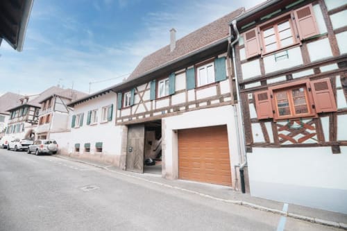 Bâtiments à colombages traditionnels sur une rue paisible à Dambach-la-Ville, France, où se trouve le gîte Le Petit Havre de Joy.