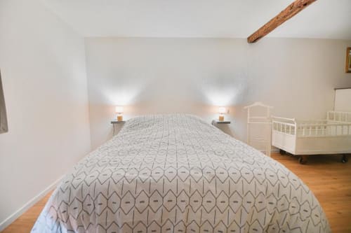 Chambre spacieuse d'un appartement 2 pièces au Petit Havre de Joy, Dambach la Ville, avec lit double, lampes de chevet et lit bébé.