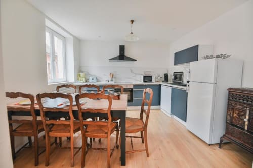 Cuisine moderne et salle à manger du Petit Havre de Joy B&B à Dambach-la-Ville, avec chaises en bois et cuisine bleue