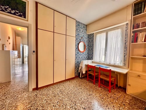 Appartamento Casa delle Palme a Varigotti con armadio panna, scrivania rossa, carta da parati decorativa e finestre con vista mare
