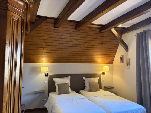 Chambre twin de l'Hôtel de l'Ange Niedermorschwihr avec poutres apparentes, literie blanche et éclairage chaleureux