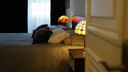 Quarto aconchegante no Santiago de Caminha Boutique Hostel com luminária Tiffany decorativa, almofadas e iluminação calorosa em Caminha
