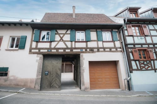 Façade à colombages d'un gîte à Dambach-la-Ville, Alsace, aux volets verts et portes en bois