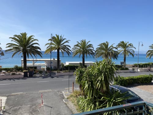 Passeggiata lungomare di Varigotti con palme e vista sul Mar Mediterraneo, hotel Welcome Varigotti sullo sfondo