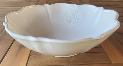 Cuenco de cerámica blanca con bordes ondulados y escudo de corona en Casale Artemisia B&B, Capalbio