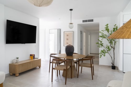 Moderno salón de apartamento con comedor, muebles de madera, televisor de pantalla plana y vistas al lago en Málaga