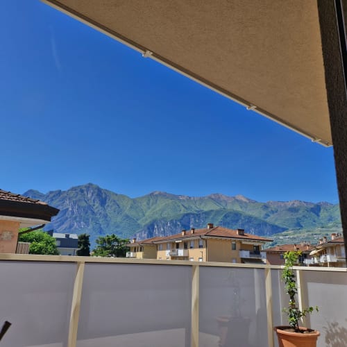 Vue du balcon de l'appartement La Casa di Silvia à Arco, Italie, avec vue sur les montagnes et la ville, store rétractable