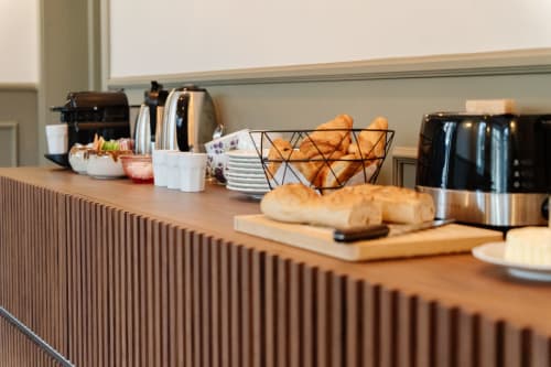 Le comptoir petit-déjeuner de l'auberge Le Falcoz avec pain frais, pâtisseries et électroménager à Saint-Jean-de-Maurienne