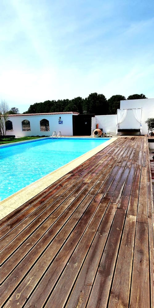 Piscina azul brilhante com deck de madeira na quinta da Herdade da Cova da Onça em Canha, Portugal
