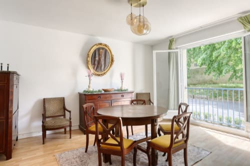 Élégante salle à manger du Versailles Luxury Retreat avec table ronde, vue sur les jardins et mobilier français classique