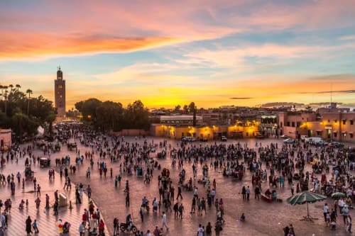 Coucher de soleil sur la place Jemaa el-Fnaa à Marrakech avec la Mosquée Koutoubia et la foule