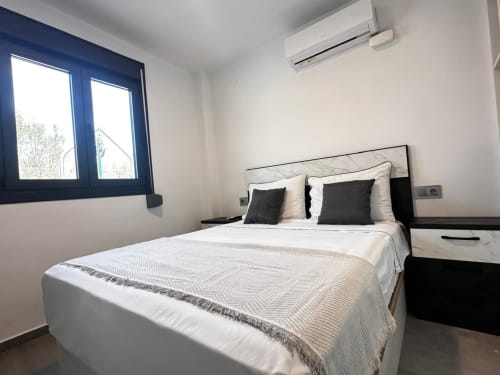 Habitación moderna en Voramar Cambrils con cama doble, aire acondicionado, Smart TV y vistas al jardín por ventanas con marco azul