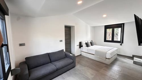 Estudio moderno en Apartaments Voramar, Cambrils con sofá, cama, TV y vistas al jardín
