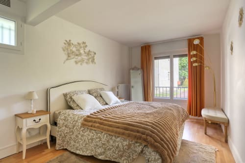 Élégante chambre avec lit queen-size, balcon vue sur jardin et rideaux couleur terre cuite à Versailles Luxury Retreat