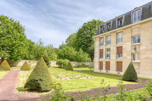 Élégant bâtiment en pierre avec jardins soignés et topiaires à l'hôtel royal Queen And King à Versailles