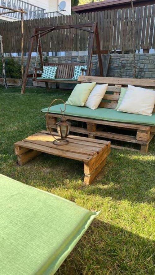 Area lounge in giardino con mobili in pallet, panche imbottite e altalena presso Cilento Rooms B&B ad Agnone