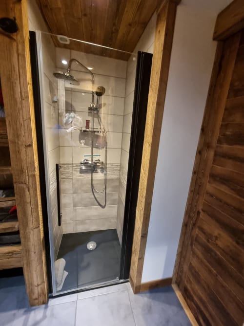 Douche à l'italienne moderne avec socle sombre, pluie de tête et douchette à main à l'appartement Zoppas Courchevel