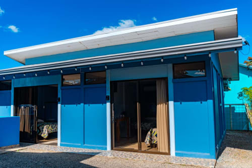 Fachada del hotel Cabinas Arenal Home en La Fortuna, Costa Rica con arquitectura moderna azul brillante y techo blanco