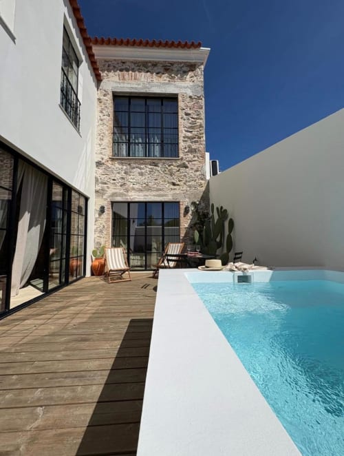 Piscina moderna do pátio do apartamento Casa Amanhada em Grândola com torre de pedra, deck de madeira e espreguiçadeiras