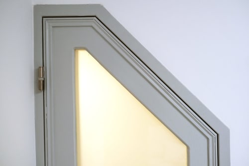Janela inclinada moderna com luz quente no quarto da pousada Santiago de Caminha, detalhe arquitetônico do design de teto inclinado