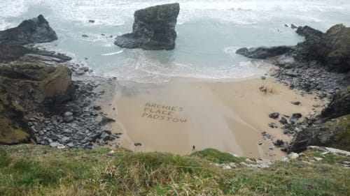 Archie's Place beach cove in Padstow with dramatic rock formations and golden sand