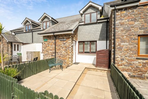 2 Doves Holiday Property exterior in Exeter featuring stone cottages with slate roofs and paved courtyard