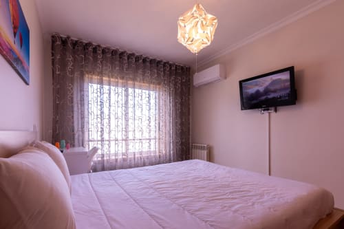 Quarto moderno rosa com vista para o mar na OceanBreeze em Perafita, Portugal - com TV, cortinas e decoração contemporânea