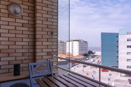 Vista da varanda do apartamento OceanBreeze no EcoHost em Perafita, Portugal, com vista para rua costeira e edifícios