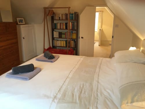 Bright attic bedroom at 2 Doves Holiday Property in Exeter with twin beds, bookshelf, and wooden furniture
