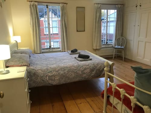 Spacious bedroom at 2 Doves Holiday Property in Exeter with double bed, wooden floors, windows overlooking town, and period