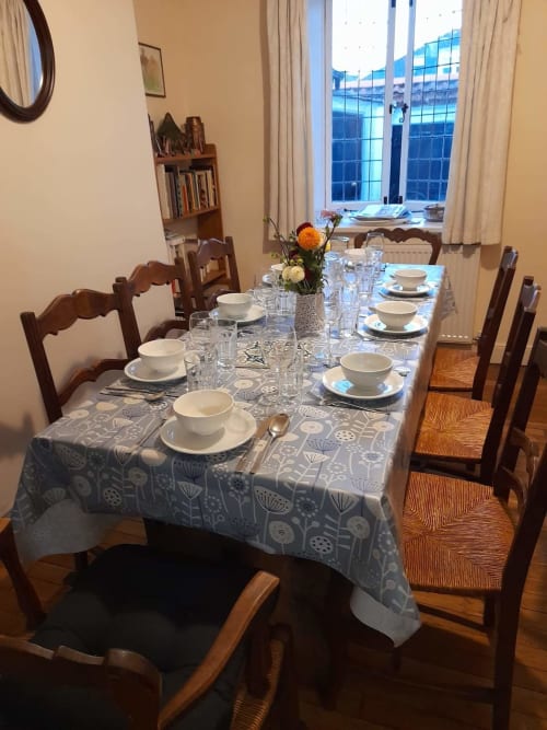 Elegantly set dining table at 2 Doves Holiday Property in Exeter with place settings, flowers, and window views