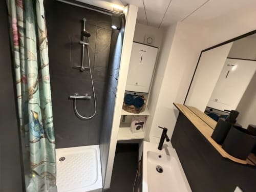 Modernes Badezimmer in La Sarrasine – okzitanisches Heritage-Ferienstudio in Aiguèze, einem der schönsten Dörfer Frankreichs mit Blick auf die Ardèche, mit Regendusche, Waschbecken und Spiegeln.
