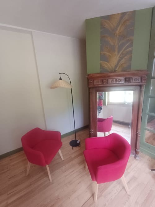 Modern sitting area at La Maison de Dun with pink armchairs, arc lamp, and ornate mirror in Saint Racho