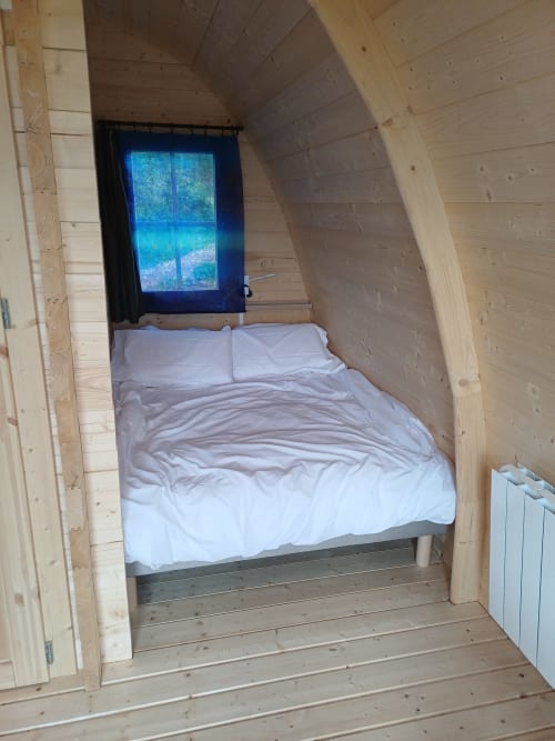 Cozy wooden pod bedroom at La Maison de Dun with bed, mountain view window, and heating at Saint Racho
