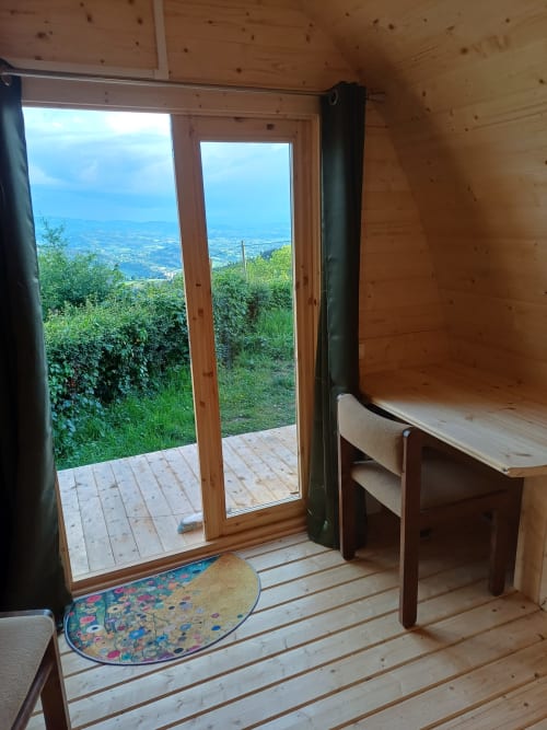 Cozy wooden pod room at La Maison de Dun B&B with mountain views, desk, and access to heated outdoor deck