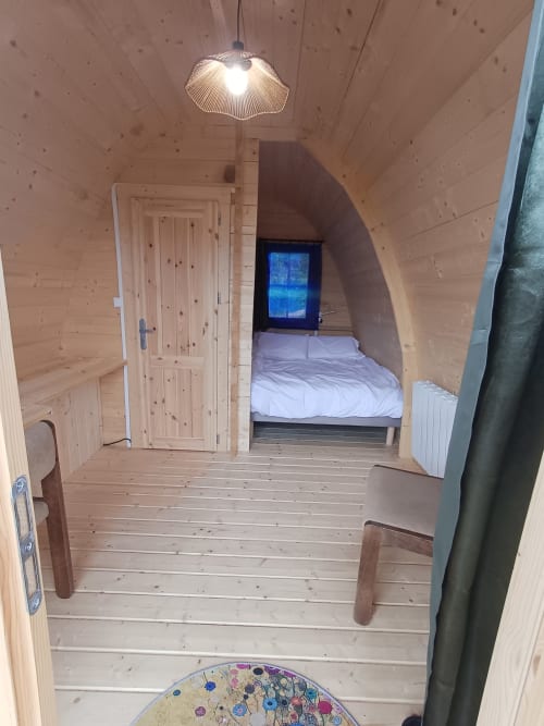 Pod Houx bedroom at La Maison de Dun B&B in Saint Racho, France with wooden walls, bed, and pendant light