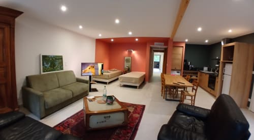 Espace de vie ouvert et contemporain aux Ateliers du Moulin, chambres d'hôtes à Poligny, avec canapé, table à manger et cuisine