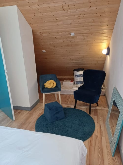 Cozy bedroom in Chambre Soleil Bleu at La Maison de Dun B&B, Saint Racho, featuring wooden ceiling, blue chairs, and mountain
