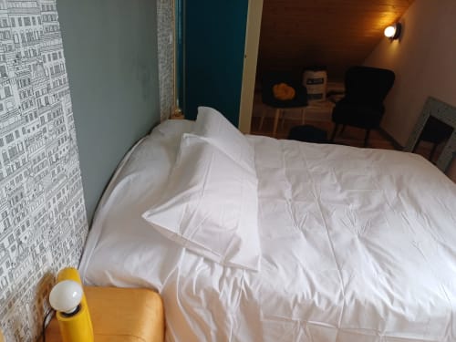 Cozy bedroom at La Maison de Dun B&B in Saint Racho with white bedding, blue accent wall, and rustic decor