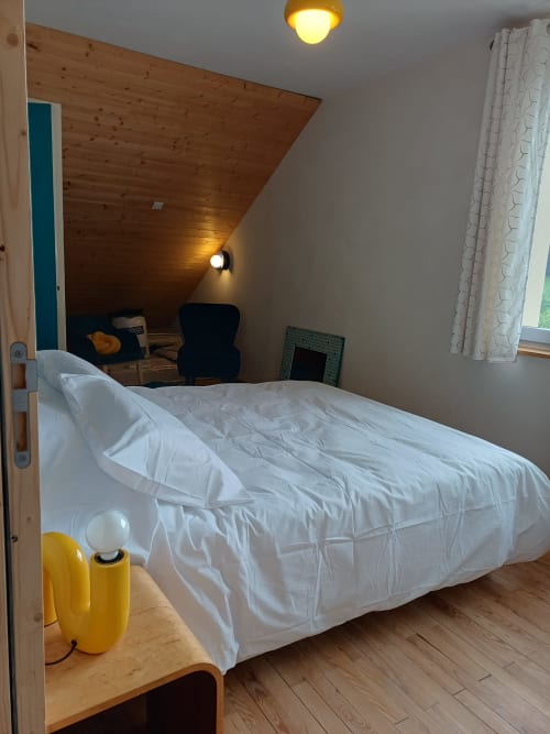 Bright bedroom at La Maison de Dun B&B in Saint Racho with white bedding, wooden ceiling, and mountain views
