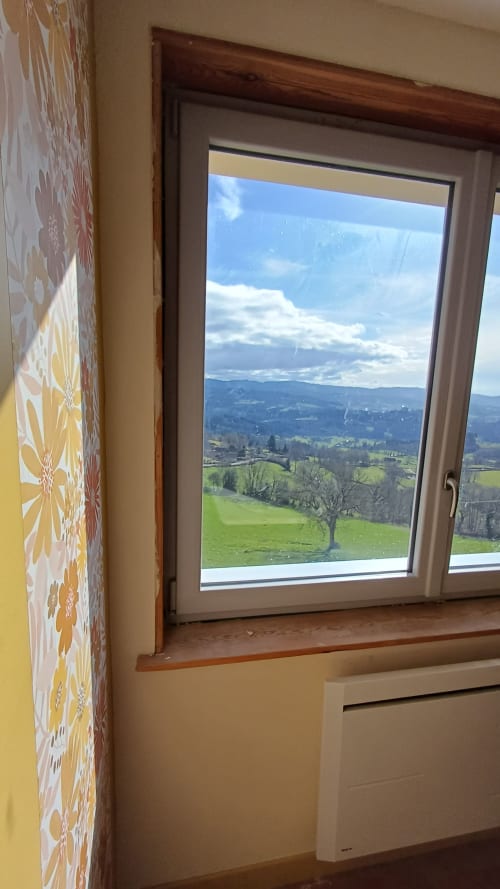 Mountain view from Chambre Passiflore window at La Maison de Dun, Saint Racho, with rolling hills and scattered trees