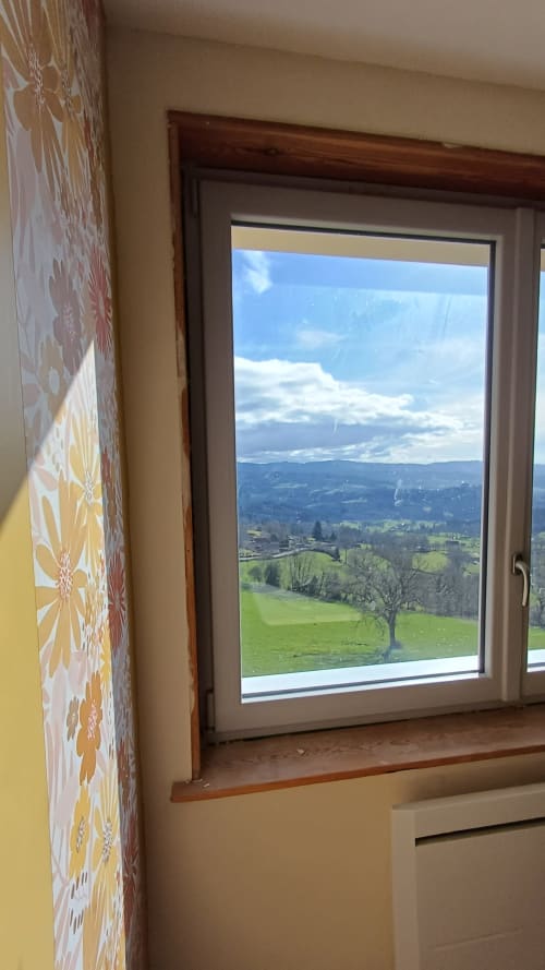 Mountain view from Chambre Passiflore window at La Maison de Dun, Saint Racho, showing green valleys and rolling hills